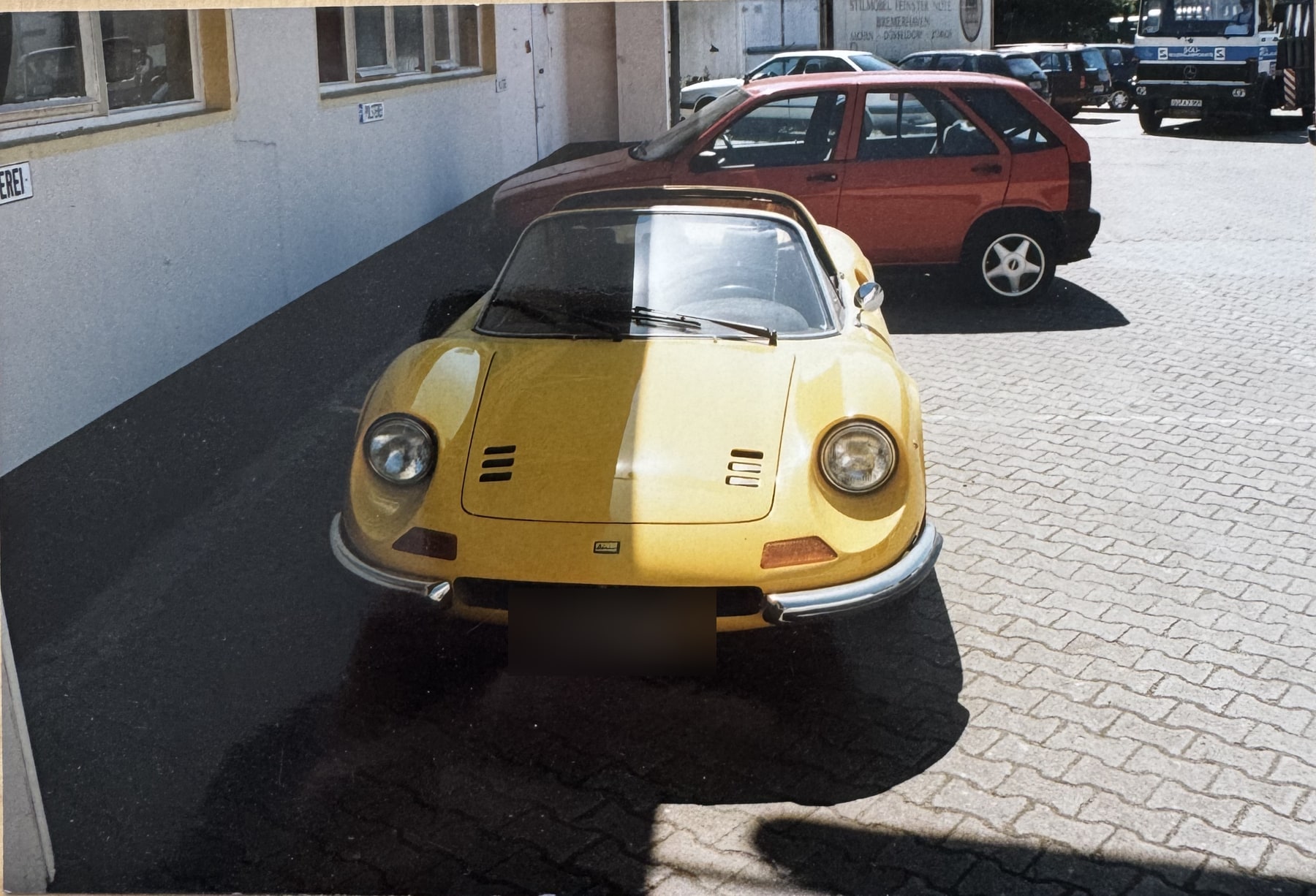 Ferrari Dino 246 GT in Gelb vor der Werkstatt, Innenraum neu bezogen.