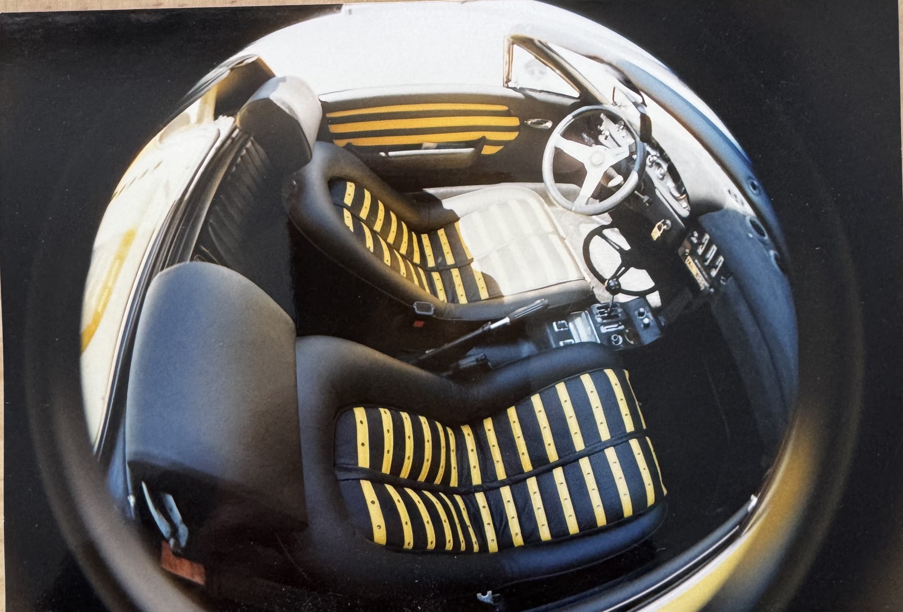 Fahrer- und Beifahrersitz des Ferrari Dino, schwarzes Leder mit gelben Querstreifen.
