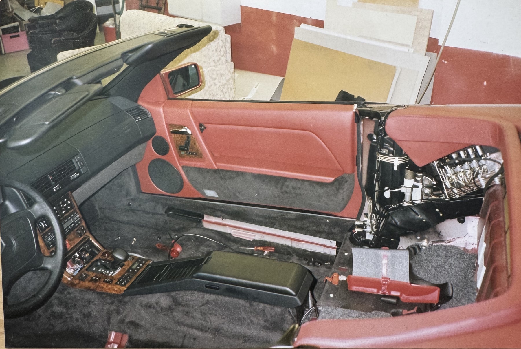 Ausgebauter Innenraum des Mercedes während der Aufarbeitung, rote Lederteile bereitgelegt.