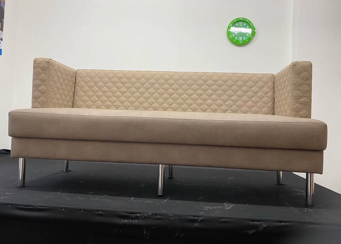 Frontalansicht der Sitzbank mit Rautensteppung in der Lehne und schlanken Chrombeinen.