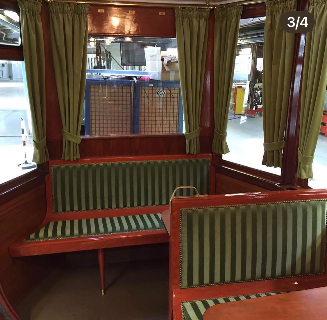 Lange Sitzbank im Kaiserwagen, neu bezogen in grün-gold gestreiftem Stoff mit Messing-Ziernägeln.